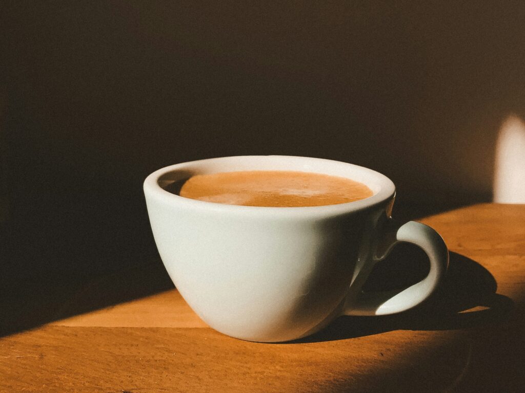 Cup of coffee on a table in the sunlight